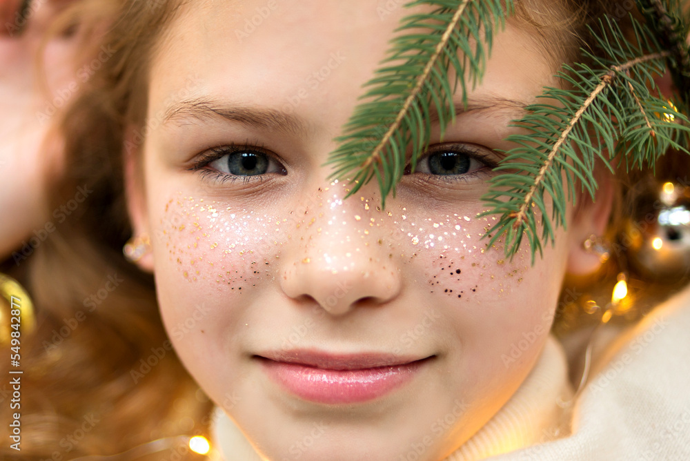 Portrait of teenager girl with pine tree brunch. Girl with golden freckles.