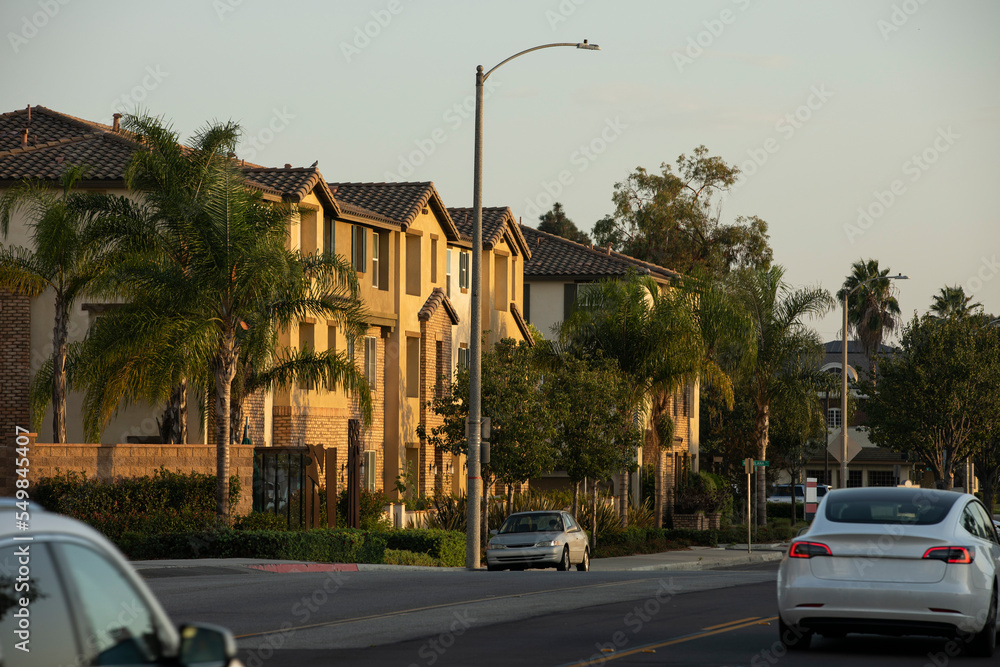 Afternoon sunset light shines on downtown housing buildings in Artesia, California, USA.