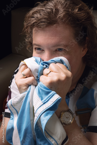 Canvastavla Hincha de futbol nerviosa apretando entre sus puños la camiseta de la selección Argentina durante evento deportivo