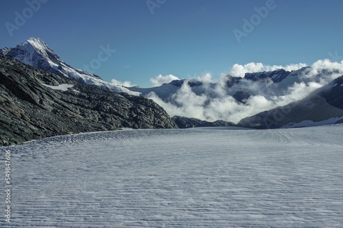 Filed covered with snow with rocky mountains in the background, Mount Aspiring, Tititea, New Zealand photo