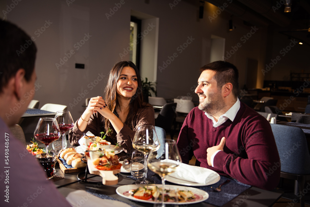 Happy business colleagues talking while eating lunch in a restaurant Happy business colleagues talking while eating lunch in a restaurant