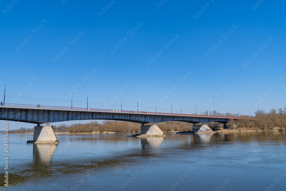 road bridge over the Vistula river in Warsaw, Poland in sunny weather against the background of blue sky and blue water