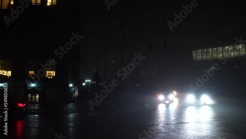 Blackout in the city. No street lightning. Light from cars during fog night.