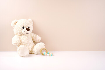 Framed border banner backdrop background. Baby shower 1st birthday christening gender neutral theme. Styled setting with white teddy bear against a beige and white background. Negative copy space.