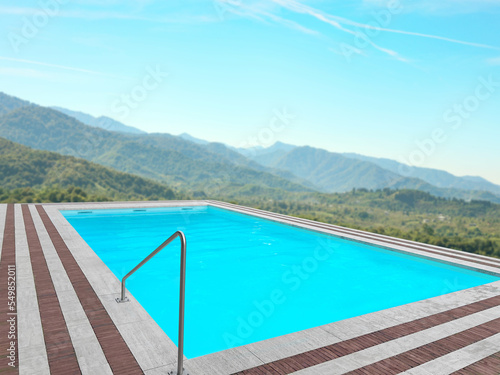 Outdoor swimming pool at luxury resort with beautiful view of mountains on sunny day © New Africa