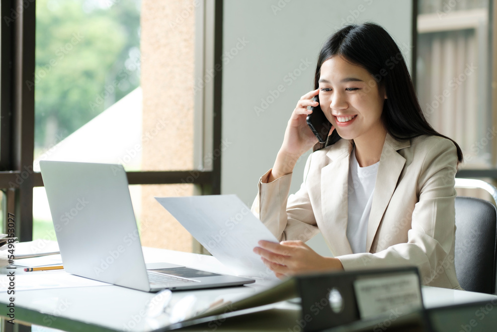Close up of Businesswoman working at office using laptop and tel Close up of Businesswoman working at office using laptop and tel