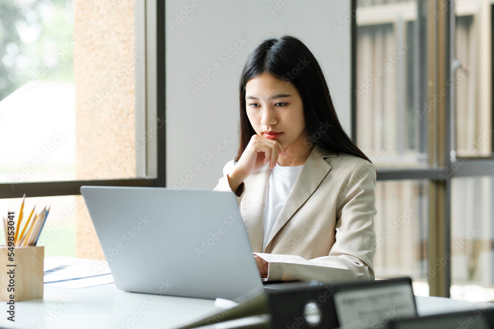 Young asian business woman or student working online on computer Young asian business woman or student working online on computer