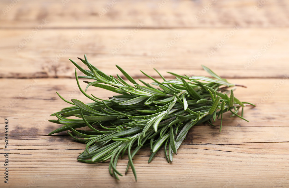 Sprigs of fresh rosemary on wooden table Sprigs of fresh rosemary on wooden table