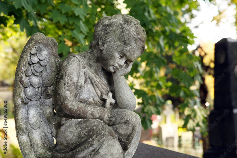 Beautiful statue of angel at cemetery on sunny day, space for text. Funeral ceremony Beautiful statue of angel at cemetery on sunny day, space for text. Funeral ceremony