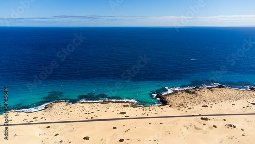 Aerial view of a road in the dunes of the Corralejo Natural Park in the north of Fuerteventura in the Canary Islands, Spain - Desertic barren landscape in the Atlantic Ocean