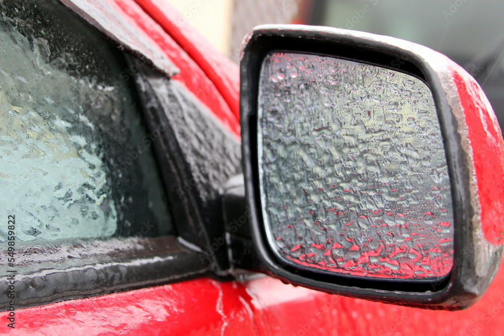 The red car is covered with ice. Icy surface of the car. The red car is covered with ice. Icy surface of the car.