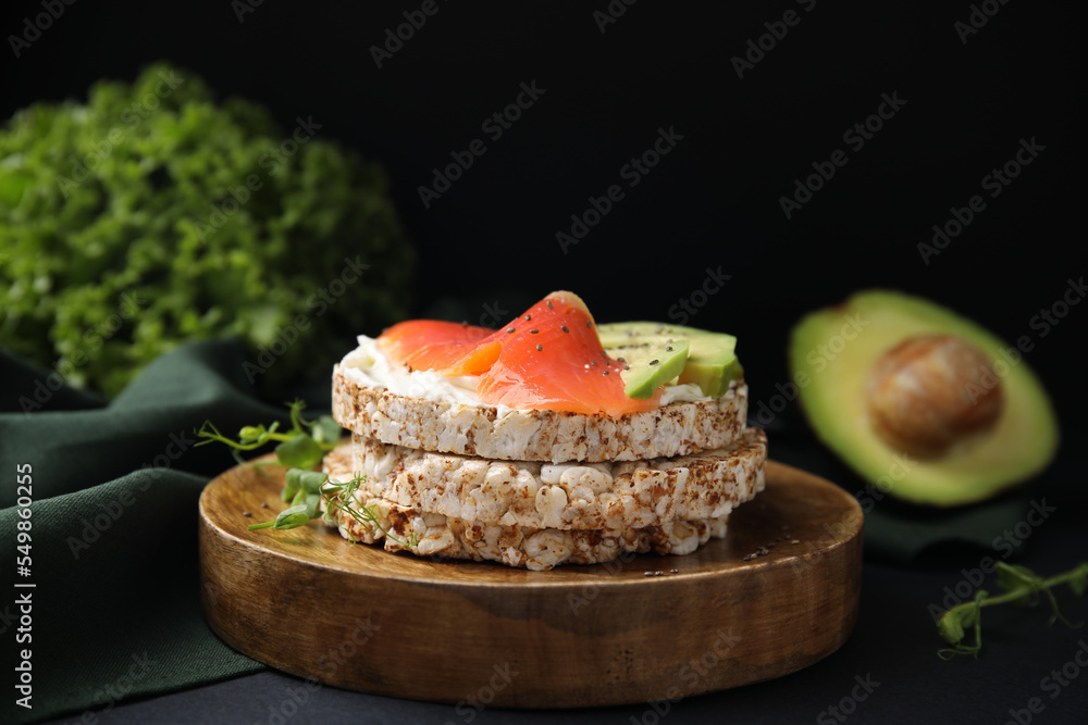 Crunchy buckwheat cakes with cream cheese, salmon and avocado on black table Crunchy buckwheat cakes with cream cheese, salmon and avocado on black table