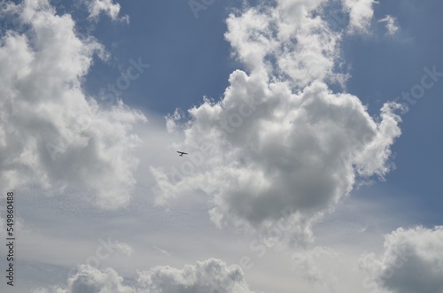 Modern airplane flying in sky with clouds