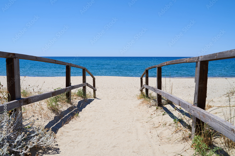 Jetty to Ascea beach in the Salerno region of southern Italy near Naples. An empty beach with beautiful sea and blue sky. Space for text.
