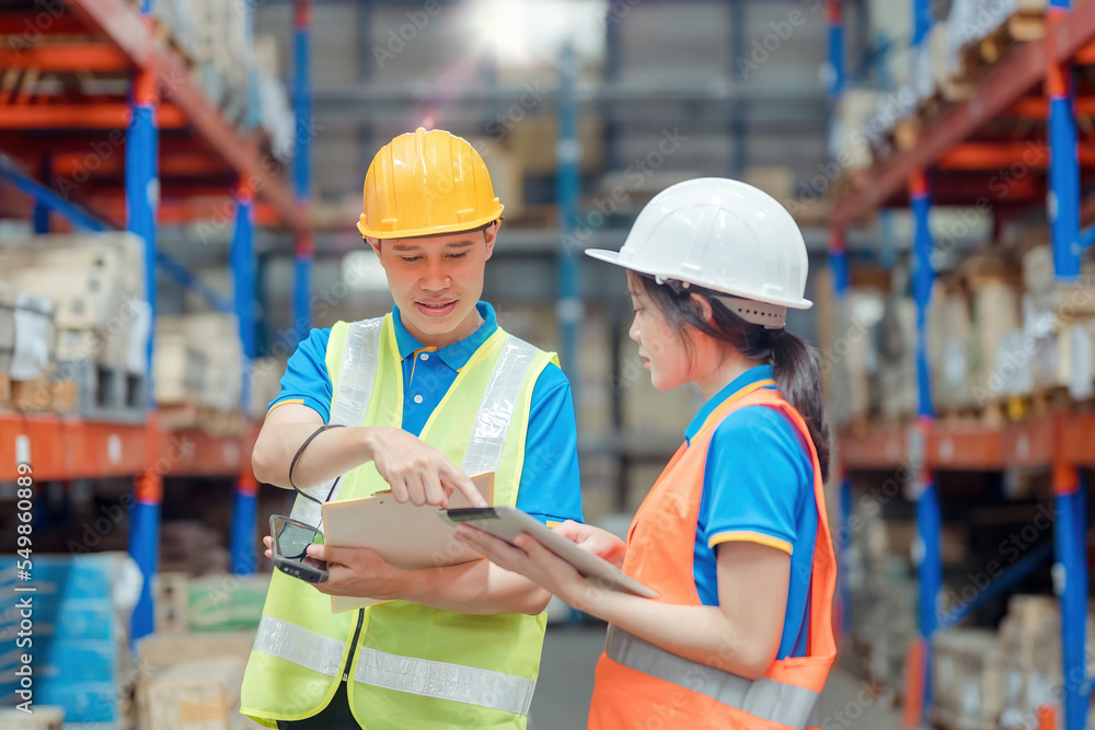 Asian engineer in helmets order and checking goods and supplies on shelves with goods background in warehouse.logistic and business export ,Warehouse worker checking packages on shelf in a large store Asian engineer in helmets order and checking goods and supplies on shelves with goods background in warehouse.logistic and business export ,Warehouse worker checking packages on shelf in a large store