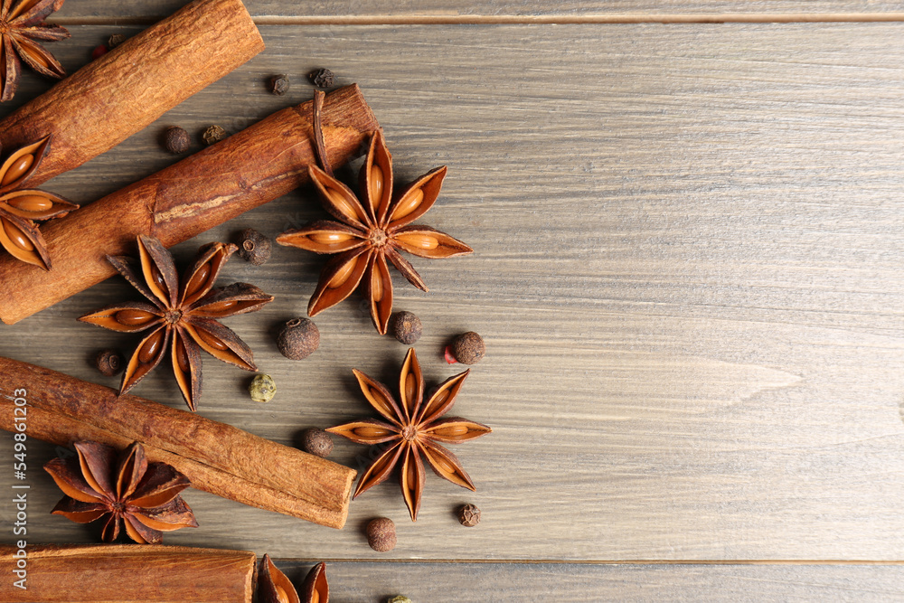 Aromatic anise stars, pepper and cinnamon sticks on wooden table, flat lay. Space for text Aromatic anise stars, pepper and cinnamon sticks on wooden table, flat lay. Space for text