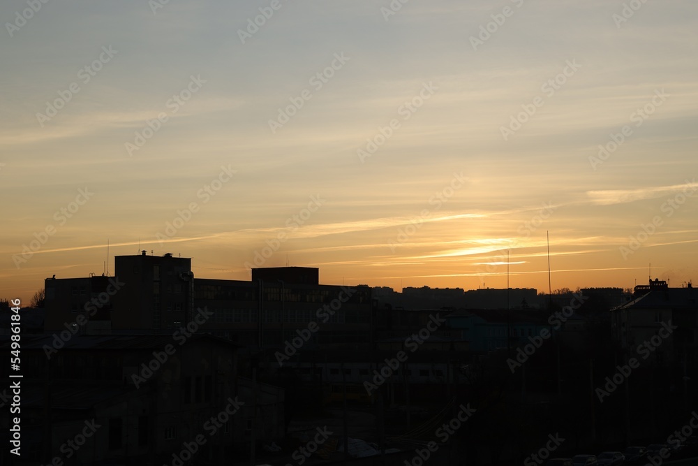 View of beautiful sky with clouds over city at sunset View of beautiful sky with clouds over city at sunset