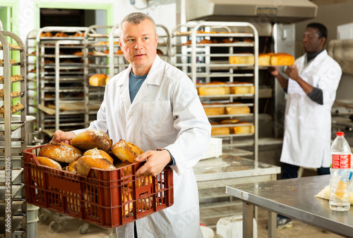 Baker sorts finished products at the bakery. High quality photo