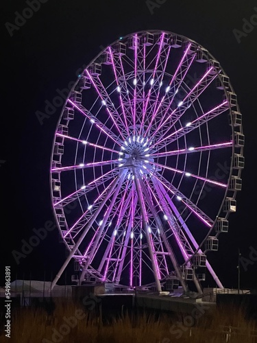 Ferris wheel in the night with purple lights