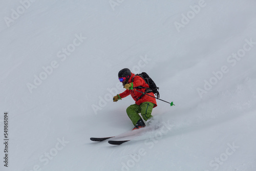 an experienced skier makes a carving turn on a steep slope