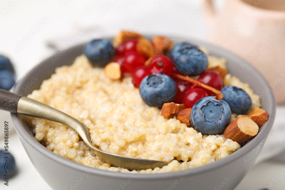Bowl of delicious cooked quinoa with almonds, cranberries and blueberries, closeup Bowl of delicious cooked quinoa with almonds, cranberries and blueberries, closeup
