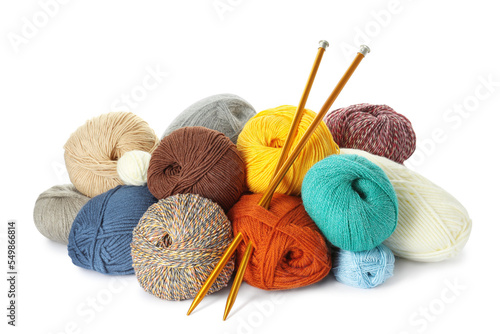 Different balls of woolen knitting yarns and needles on white background
