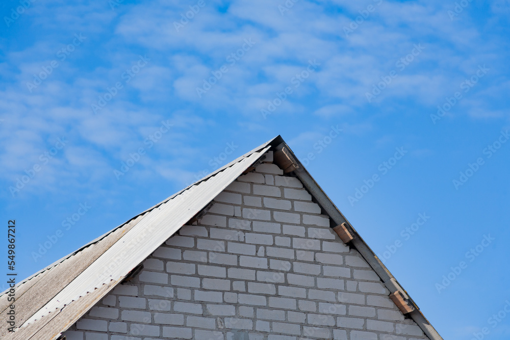 Roof of the world. The roof of a rural house close-up against the blue sky. Roof close-up. Low angle view.