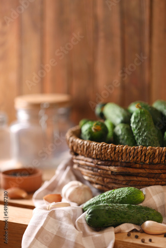 Fresh cucumbers and other ingredients prepared for canning on wooden table
