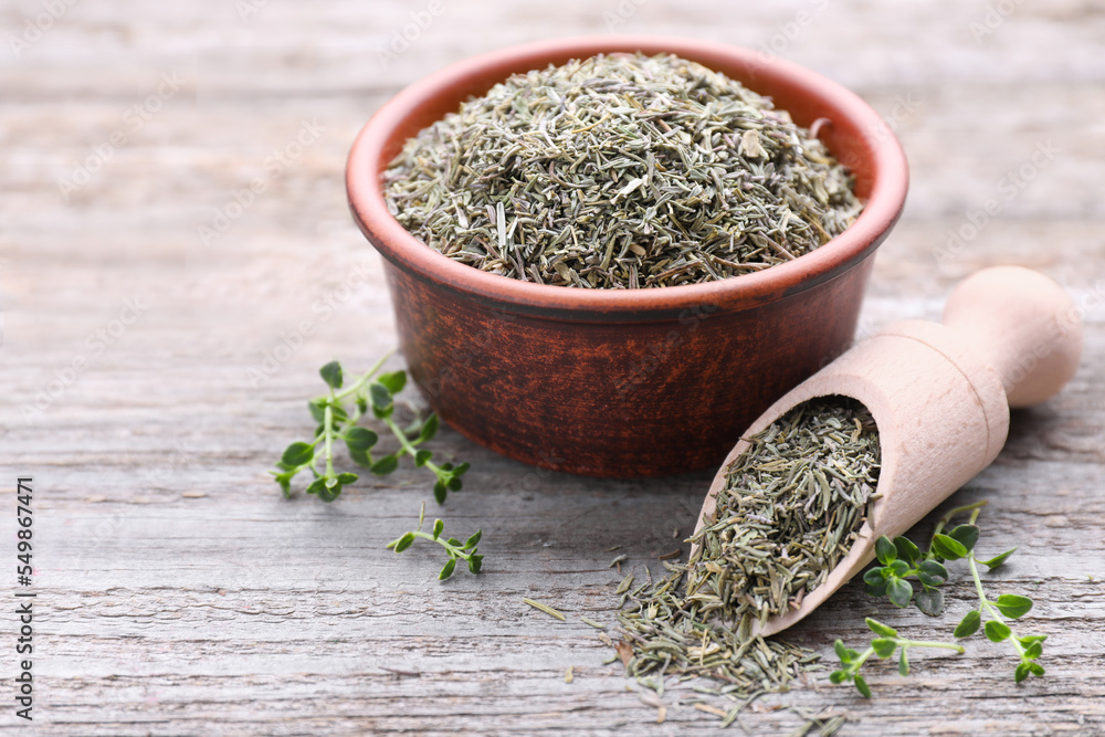 Bowl with scoop of dried and fresh thyme on wooden table, closeup Bowl with scoop of dried and fresh thyme on wooden table, closeup