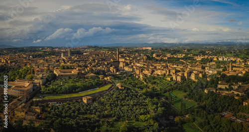 Scenery of Siena, a beautiful medieval town in Tuscany, view of the Dome and Bell Tower of Siena Cathedral, landmark Mangia Tower and Basilica of San Domenico,Italy. Aerial drone shot, october 2022