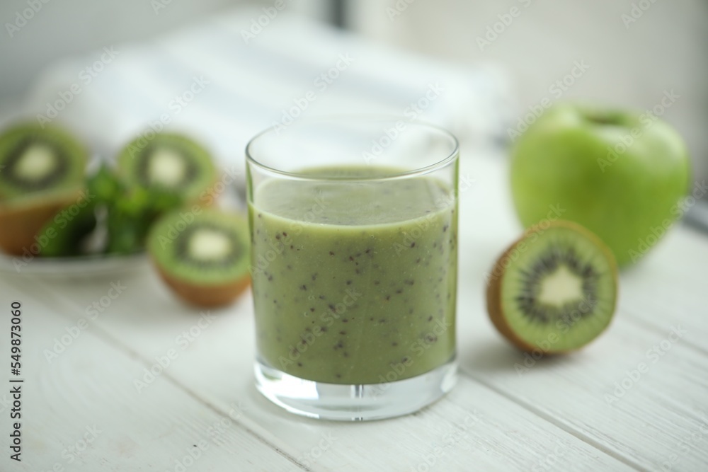 Delicious kiwi smoothie and fresh fruits on white wooden table Delicious kiwi smoothie and fresh fruits on white wooden table
