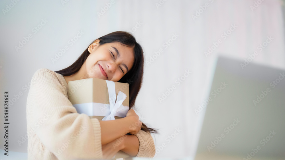 Young asian woman using computer laptop at home. Female showing gift box while on video conversation with friend. Happy birthday, Happy new year, Thanksgiving - obrazy, fototapety, plakaty 