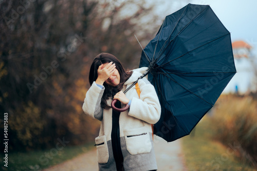 Woman with Broken Umbrella Walking in a Storm. Stressed girl trying to go home during bad weather day 