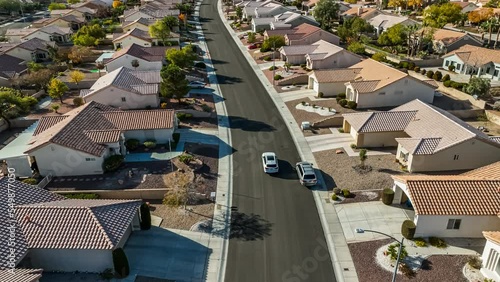 Aerial view of a car driving away on a suburban neighborhood road in Nevada; 4k footage