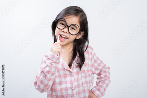 little girl Asia brushing teeth happily white background