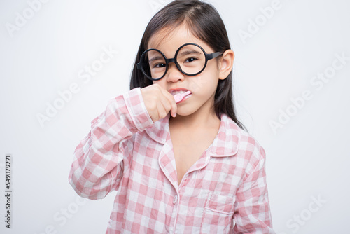 little girl Asia brushing teeth happily white background