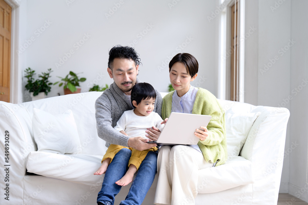 リビングにて家族でパソコンを覗いているイメージ リビングにて家族でパソコンを覗いているイメージ