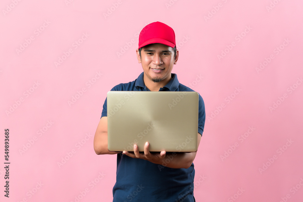 Professional courier in red cap, working typing on laptop. Service concept Professional courier in red cap, working typing on laptop. Service concept