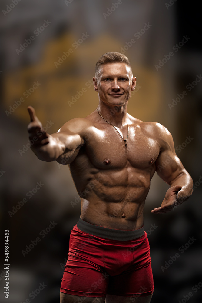 Muscular man with a naked torso shows an inviting gesture with his hands