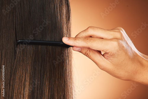 Hair care, back and hand with comb for beauty, growth and grooming in a studio background with mockup. Relaxed, texture and luxury hairdresser brushing a woman or clients healthy head at salon