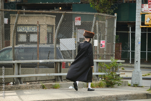 a hasidic jewish man walking down the street in williamsburg brooklyn