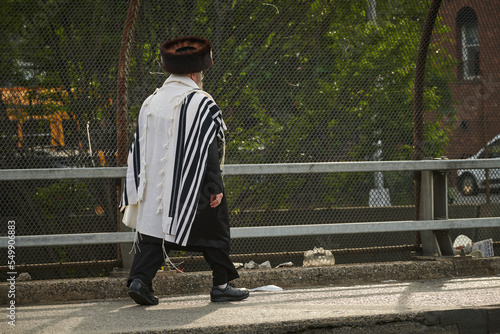 a hasidic jewish man walking down the street in williamsburg brooklyn