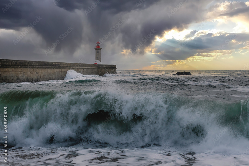 Storm waves over the lighthouse in a cloudy evening, Oporto, Portugal