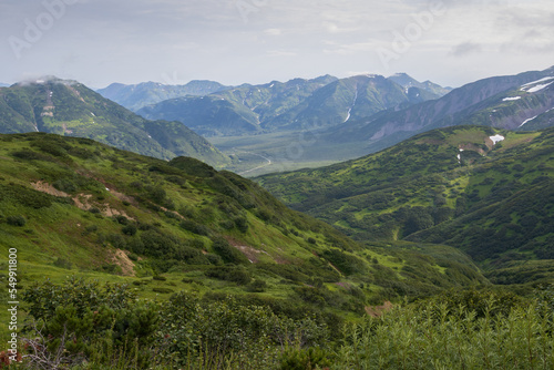 Summer mountain landscape. View from the mountains to the valley. Travel, tourism and hiking on the Kamchatka Peninsula. Beautiful nature of Siberia and the Russian Far East. Kamchatka Krai, Russia.