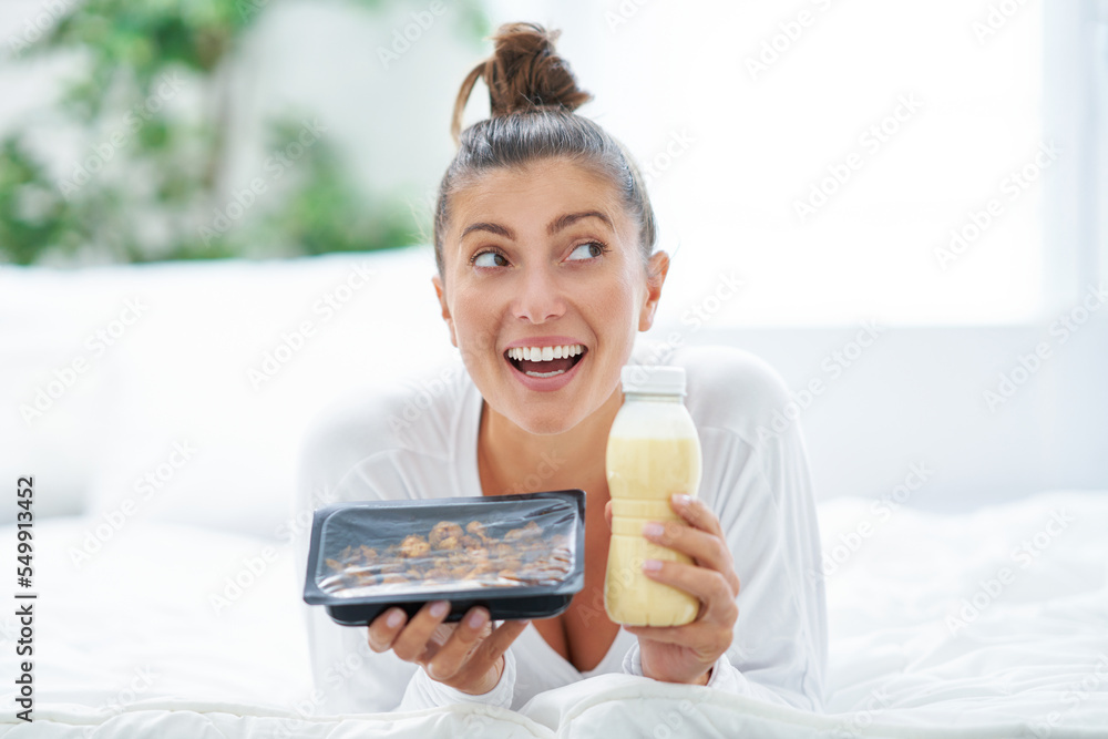 Young woman on bed with food catering box Young woman on bed with food catering box