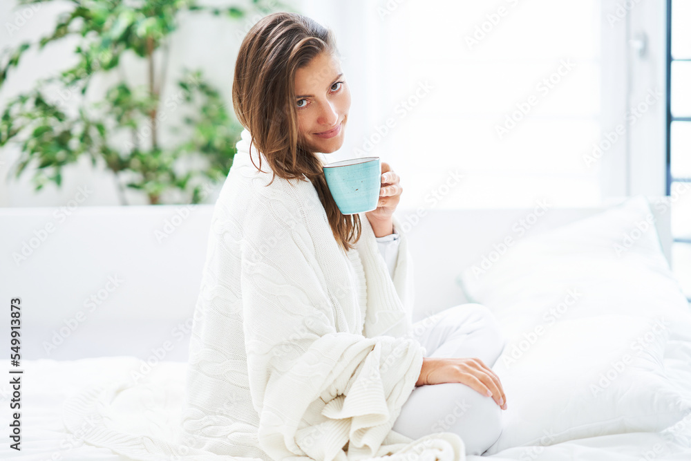 Young nice woman in bed with coffee or tea mug Young nice woman in bed with coffee or tea mug