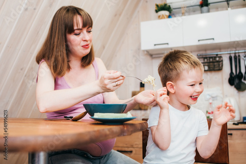 Photography Little child refuses to eat pasta in the kitchen