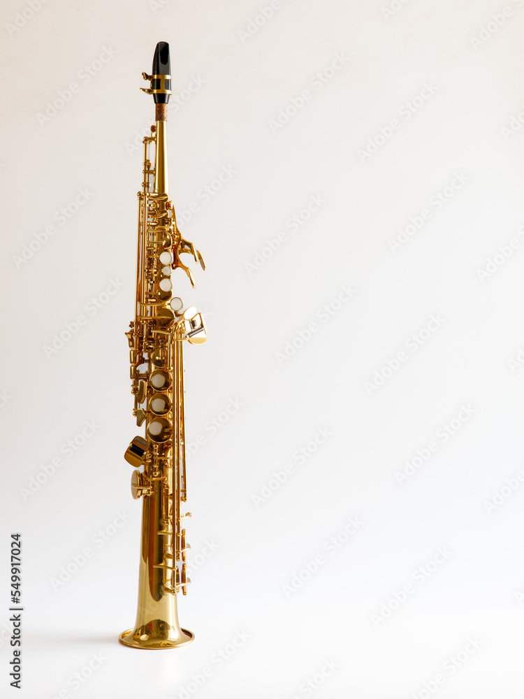 Soprano Sax, wind instrument saxophone staying on a white background, vertical, copy space. Soprano Sax, wind instrument saxophone staying on a white background, vertical, copy space.
