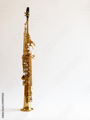 Soprano Sax, wind instrument saxophone staying on a white background, vertical, copy space. photo