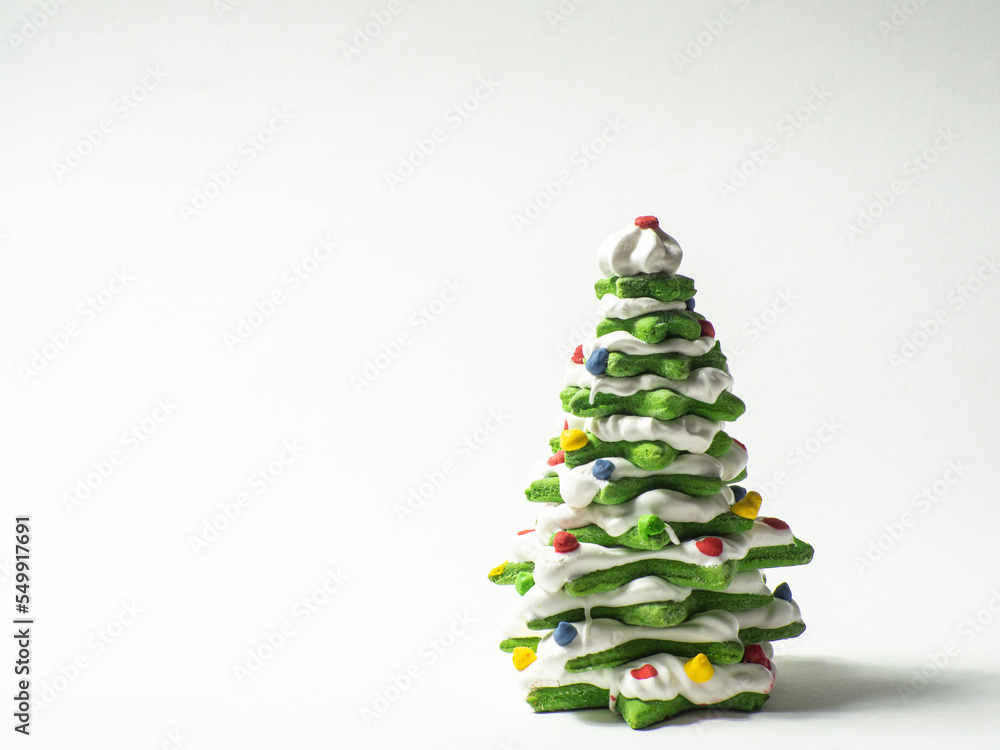 Green cookie christmas tree made by star cookie cutter on white background. New Year Christmas card. Matcha Green Tea Gingerbread Christmas tree Cookies covered with white chocolate. Copy space. Green cookie christmas tree made by star cookie cutter on white background. New Year Christmas card. Matcha Green Tea Gingerbread Christmas tree Cookies covered with white chocolate. Copy space.